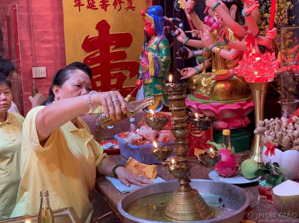 Du kh&aacute;ch thực hiện nghi thức r&oacute;t dầu cầu an tại ch&ugrave;a Ngọc Ho&agrave;ng